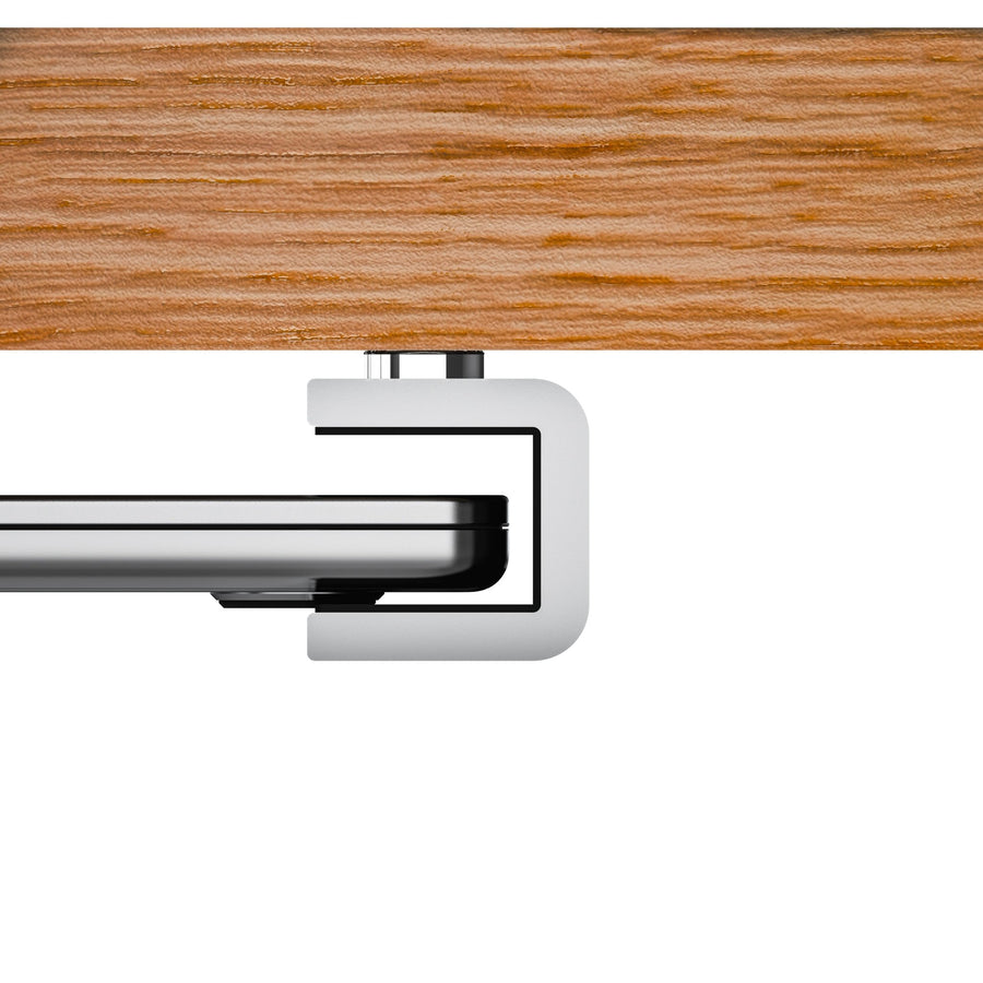 Aluminium holder of the MacBook Shelf clamped to the underside of an oak desk
